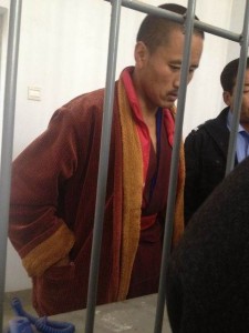 An unshaven and gaunt-looking Gartse Jigme being questioned at Public security Bureau office in Rebkong. 