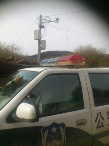 Surveillance camera visible on the electric pole behind the police patrol car at Muge Monastery.