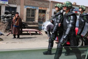 Chinese paramilitary troops pass by a Tibetan man in Gomang Township in Tsolho Tibetan Autonomous Prefecture, Qinghai Province, in Tibetan province of Amdo. (Frederic J. Brown/AFP/Getty Images)