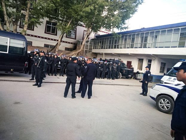 Chinese police keep watch over protesters outside local government office in AMchok